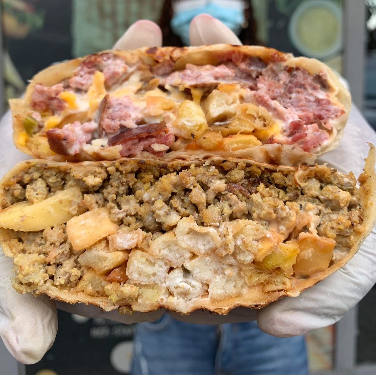 Tacos Delmas coupé en deux, garni de viande hachée, frites et sauce